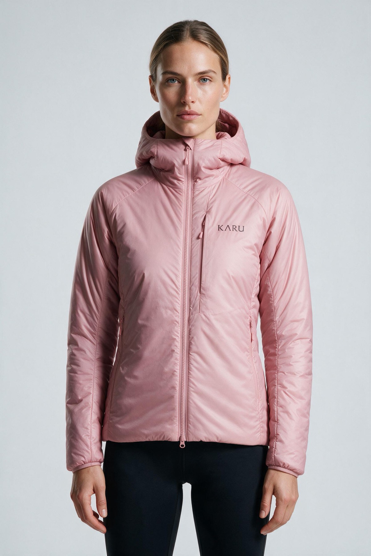 Aktse Insulated Rose in pale rose pink, worn by a model, studio product shot on a seamless neutral ground